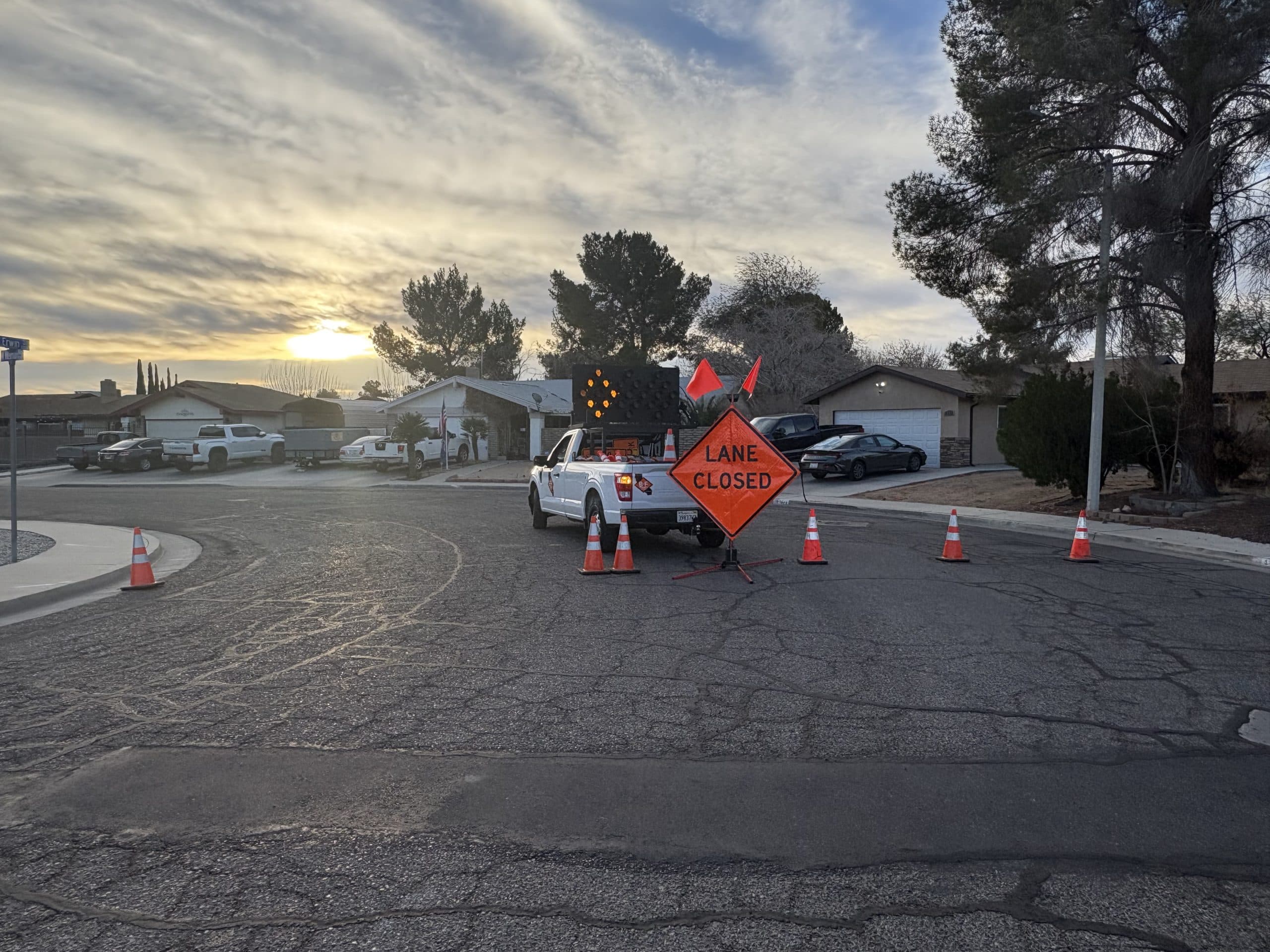 Lane Closed sign and cones at dusk with a B&F truck and arrow board